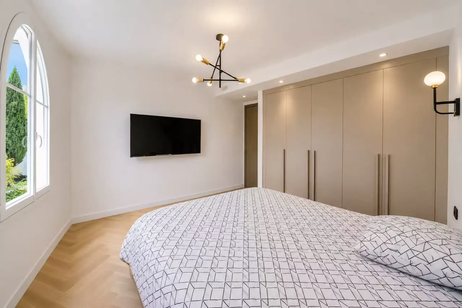 Bedroom with TV wall and built-in wardrobes