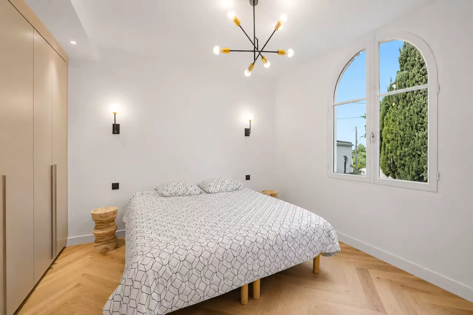 Bedroom with arched window and chandelier