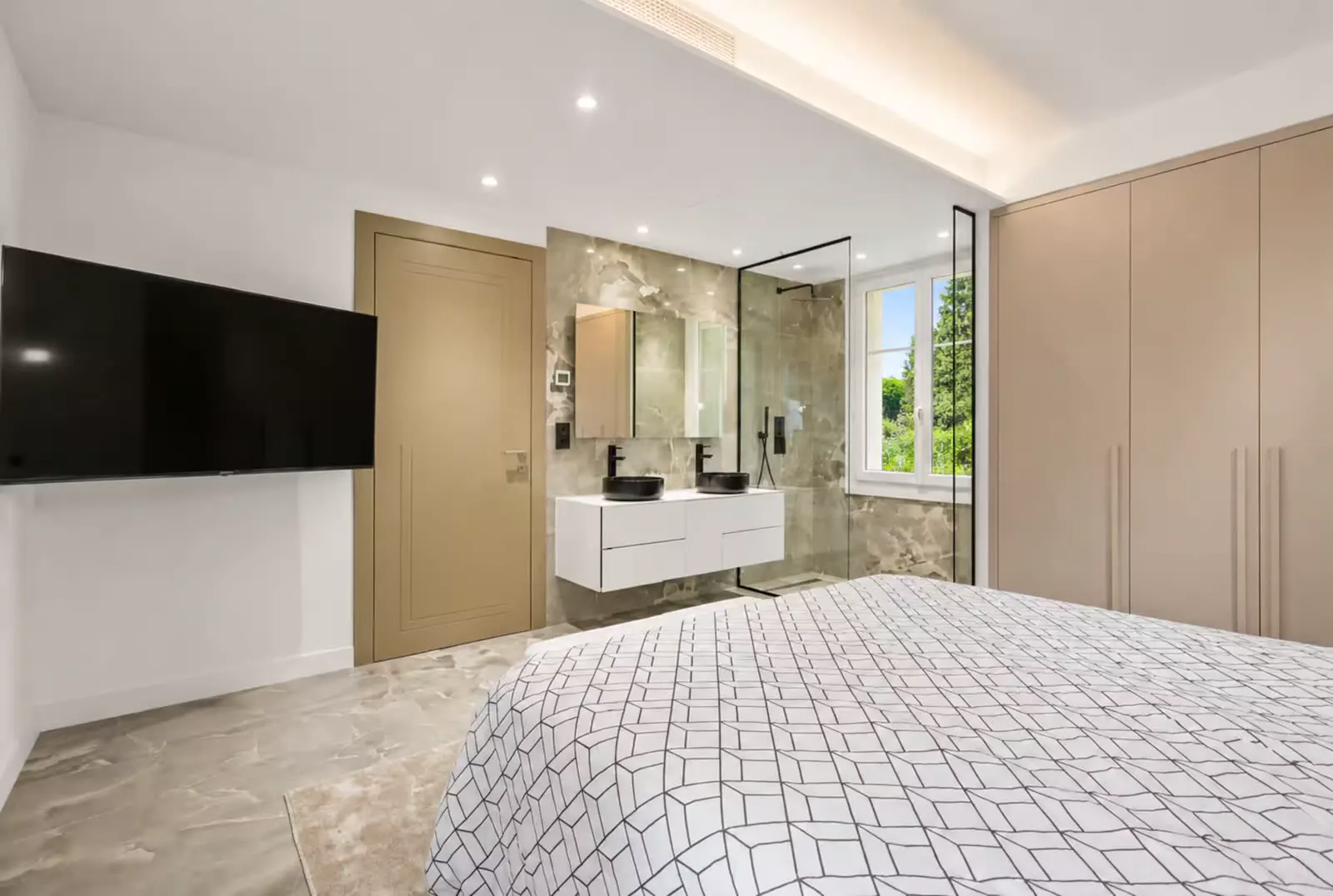 Bedroom with beige marble ensuite bathroom